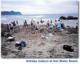 Photo of holiday makers on the sand at Hot Water Beach