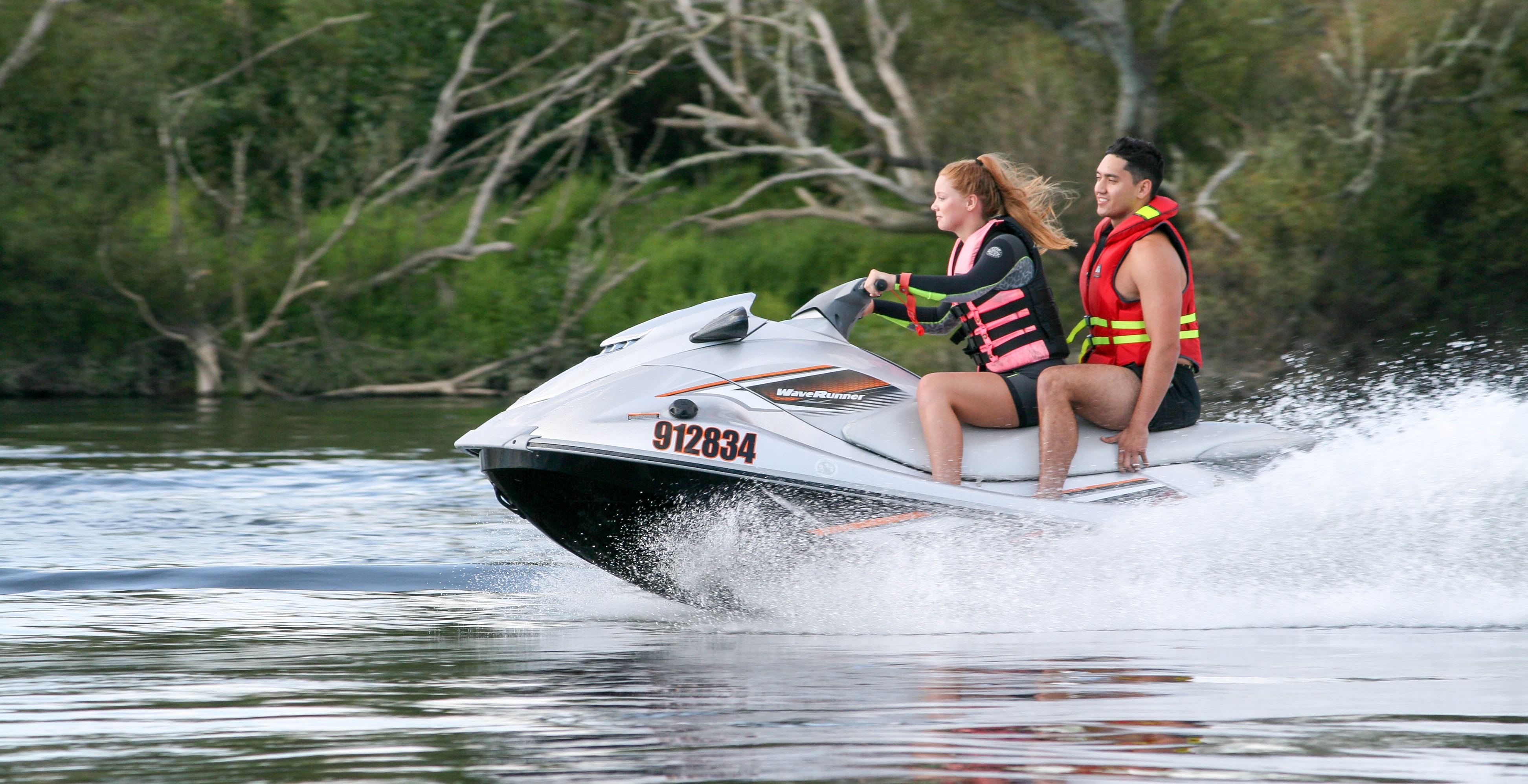 Image - Two people riding a jetski on a river