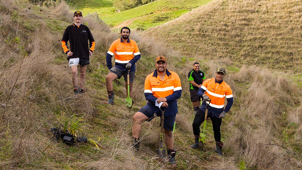 People posing with shovels from Ngati Haua Mahi Trust while out doing planting work.