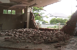 Photo taken inside a Christchurch home depicting earthquake damage. Looking out through the demolished brick wall.